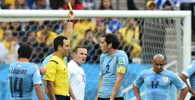 Velasco Carballo le enseña tarjeta amarilla a Diego Godín en el Uruguay-Inglaterra del Mundial de Brasil 2014. /AFP