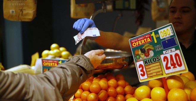 Una mujer compra fruta en un mercado de Madrid. REUTERS