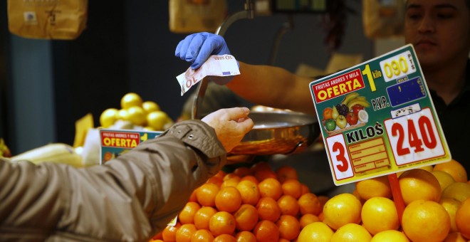 Una mujer compra fruta en un mercado de Madrid. REUTERS