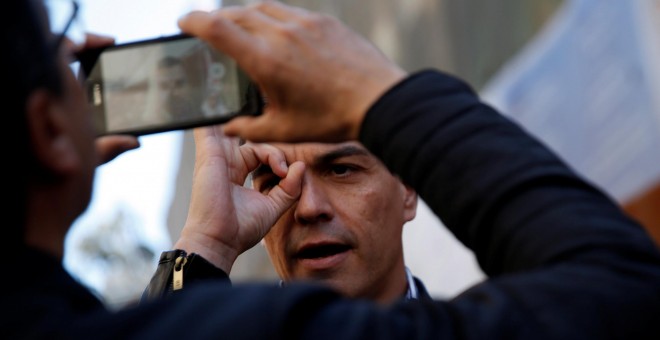 El líder socialista, Pedro Sánchez, hace un gesto mientras le toman una foto con un móvil, en la jornada del Primero de Mayo, en Madrid. REUTERS/Susana Vera