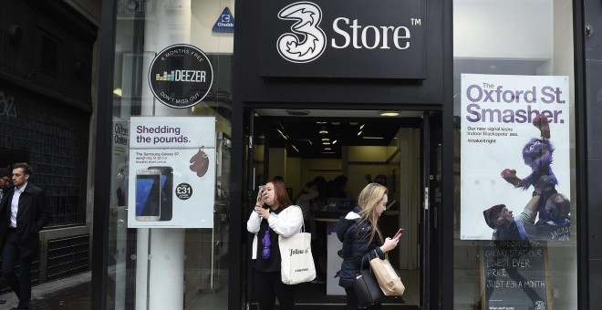 Una joven pasa por delante de una tienda del operador móvil de Hutchison, Three, en Londres. EFE/Facundo Arrizabalaga