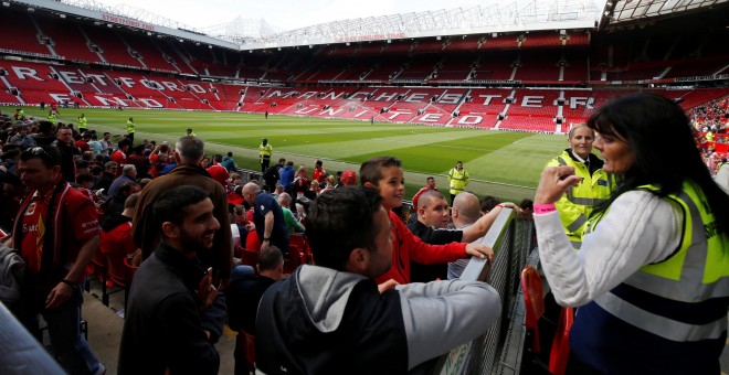 Los miembros de la seguridad del estadio del Manchester United ordenan evacuar el recinto a los espectadores por la presencia de un paquete sospechoso. REUTERS