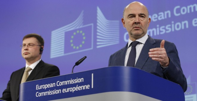 El comisario europeo de Asuntos Económicos y Monetarios, Pierre Moscovici, y el vicepresidente para el Euro y el Diálogo Social, Valdis Dombrovskis, durante una rueda de prensa celebrada en Bruselas. EFE/OLIVIER HOSLET