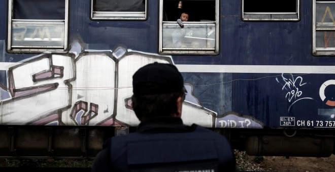 Un niño mira a través de la ventana de un tren, durante el desalojo policial del campamento de Idomeni, en la frontera entre Grecia y Macedonia. REUTERS/Yannis Kolesidis