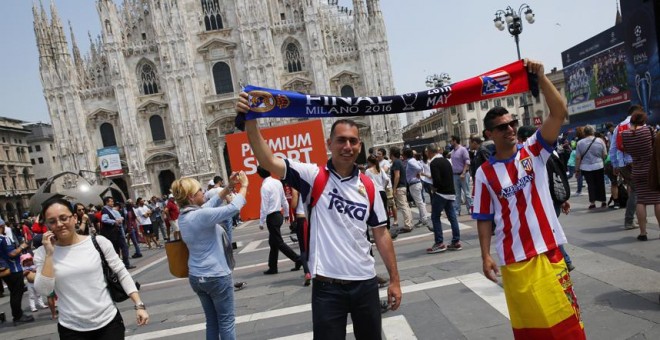 Dos aficionados en la Piazza del Duomo, en Milán, donde este sábado se disputa la final de la Champions League entre el  Real Madrid y el Atletico Madrid. REUTERS / Stefan Wermuth Livepic