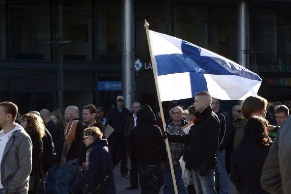 Un manifestante antiinmigración con una bandera de Finlandia durante una protesta en Helsinki. - AFP