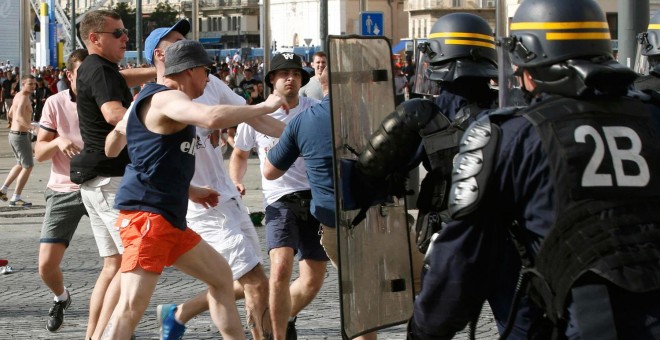 Ultras ingleses dan patadas a los escudos de los antidisturbios ayer por la tarde en Marsella. /REUTERS