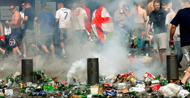 Hinchas ingleses se apartan tras lanzar un petardo en una calle llena de desperdicios y botellas de cerveza vacías. /REUTERS