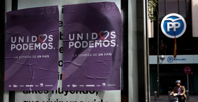 Carteles electorales de Unidos Podemos colocados cerca de la sede del PP en Madrid. REUTERS/Andrea Comas