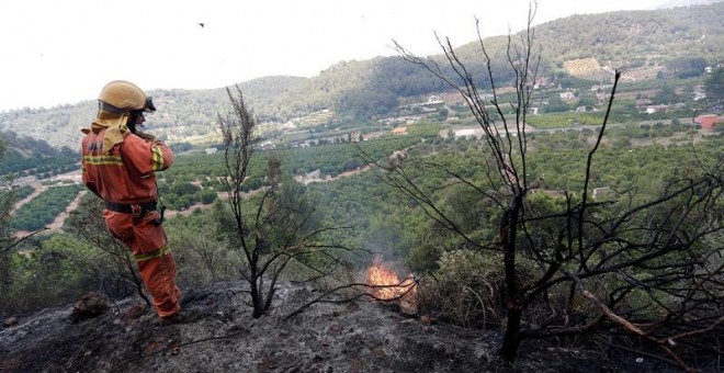 Un brigadista forestal trabaja en el frente del incendio forestal en la localidad de la Barraca de Aguas Vivas (Valencia). Cuatro incendios forestales afectan a una decena de municipios en Valencia, el más preocupante en Carcaixent, donde han sido evacuad