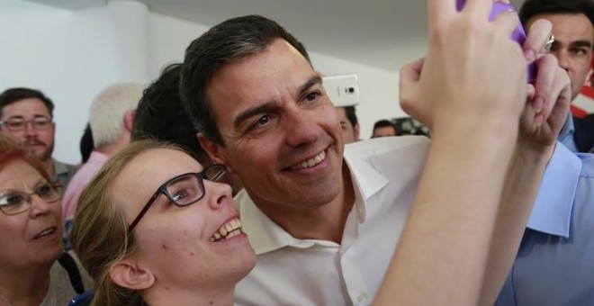 El secretario general del PSOE, Pedro Sánchez, se hace una fotografía con una simpatizante durante el acto electoral con las Juventudes Socialistas, en el Centro Cultural Tomás y Valiente, en la localidad madrileña de Fuenlabrada./ EFE