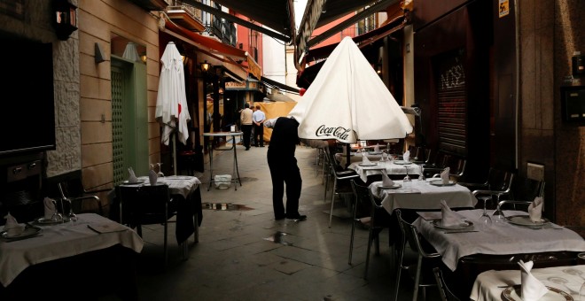 Un camarero despliega una sombrilla de la terraza de un bar en Sevilla. REUTERS/Marcelo del Pozo