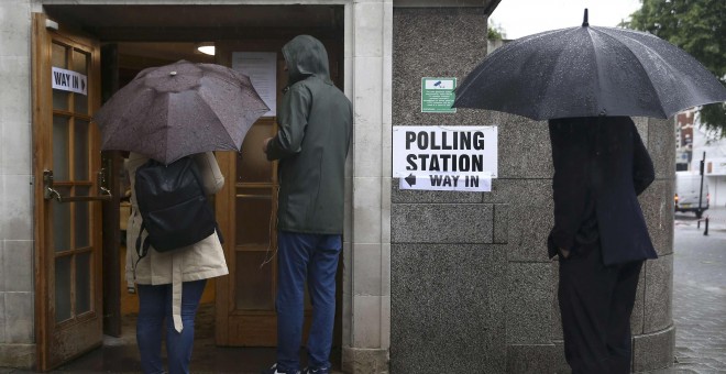 Ciudadanos británicos en la entrada de un colegio electoral. REUTERS/Neil Hall