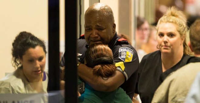 Varias personas junto a un policía de Dallas en un hospital. REUTERS