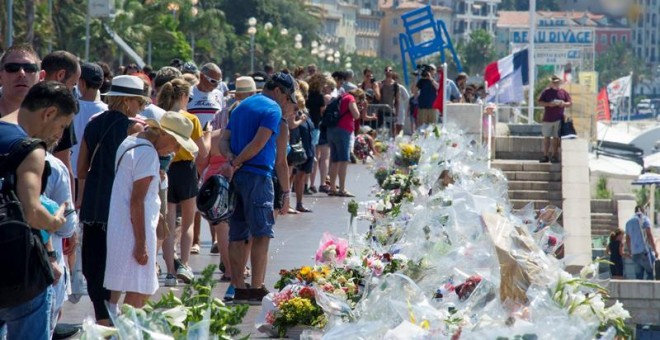 Multitud de personas se detienen ante las flores y velas depositadas en el paseo de los Ingleses en recuerdo a las víctimas cinco días después del atentado de Niza. - EFE