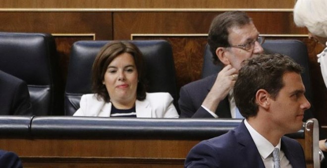 El presidente de Ciudadanos, Albert Rivera (d), pasa por delante de los escaños del presidente del Gobierno en funciones, Mariano Rajoy (detrás-d), y la vicepresidenta en funciones, Soraya Sáenz de Santamaría, en la constitución del Congreso. EFE