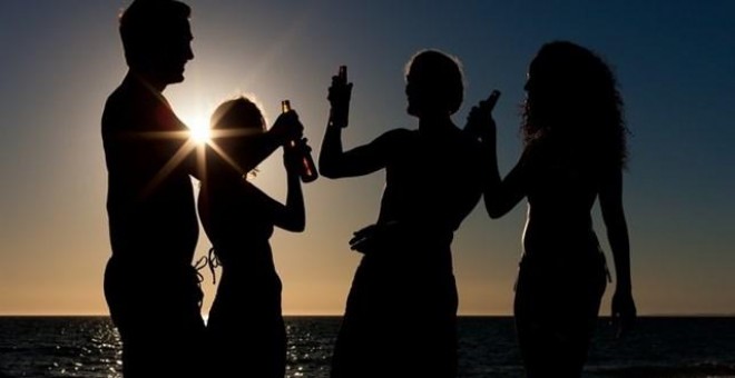 Jóvenes consumen alcohol en la playa al atardecer.- E.P.