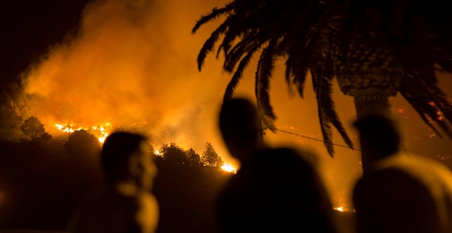 Un grupo de gente contempla como el fuego arde sin control en Las Manchas, en la isla de Palma. REUTERS/Borja Suarez