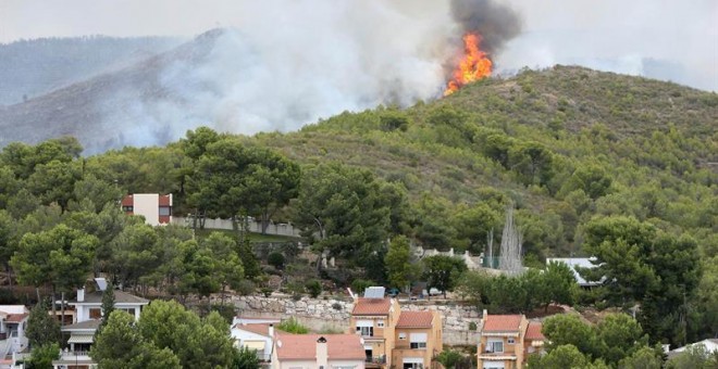 Imagen del incendio en La Pobla de Montornès (Tarragona) donde los Bomberos han desalojado hoy la parte alta de la urbanización Castell de Montornès como medida de precaución ante un incendio que arde sin control en una zona forestal de difícil acceso. EF