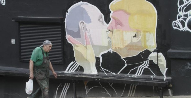 Vista de un mural de grafiti del artista lituano Mindaugas Bonanu hoy, jueves 4 de agosto de 2016, que representa al candidato presidencial republicano de EE.UU. Donald Trump (d) besar el presidente ruso Vladimir Putin (i) en la pared de un restaurante d