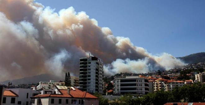Vista del humo que se levanta en el cielo de Funchal, Madeira, Portugal. 238 efectivos entre bomberos, retenes y militares combaten los multiples incendios auxiliados por 75 vehículos por tierra y dos aviones anti-incendios. Dos cuerpos de bomberos de Fun