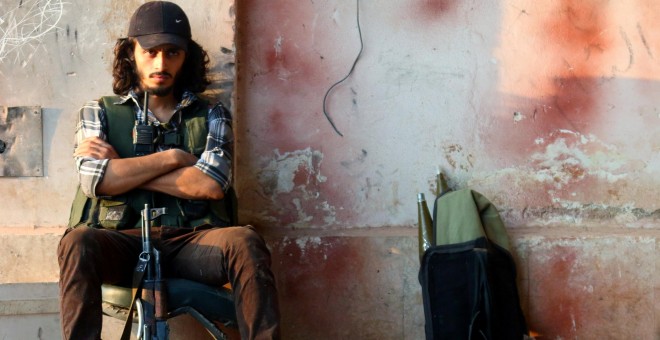 Un soldado rebelde se sienta abrazado a su arma en la academia de artillería de Alepo, Siria. REUTERS/Ammar Abdullah