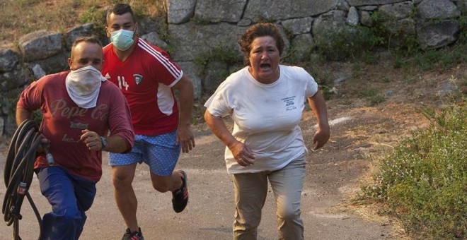 Tres vecinos acuden sofocar el incendio que se ha declarado esta tarde en el ayuntamiento pontevedrés de Soutomaior, en la parroquia de Arcade, que ha obligado a la Consellería de Medio Rural ha decretar, como medida preventiva, la 'situación 2' por su pr