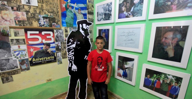 Marlon Mendez, de diez años, que se proclama admirador del líder de la revolución cubada, Fidel Castro, junto a las fotos que decoran su dormitorio, en su vivienda de San Antonio de los Baños (Cuba). REUTERS/Enrique De La Osa