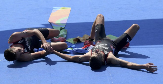 Los hermanos Brownlee tirados en el suelo tras entrar primero y segundo en la línea de meta. /REUTERS