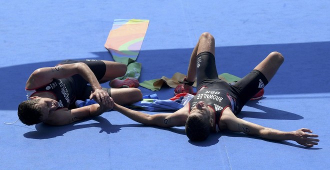 Los hermanos Brownlee tirados en el suelo tras entrar primero y segundo en la línea de meta. /REUTERS