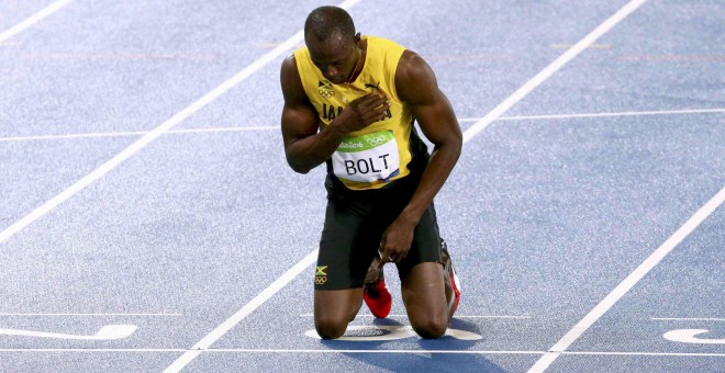 Usain Bolt, arrodillado, tras ganar la medalla de oro en los 200 metros. REUTERS/David Gray