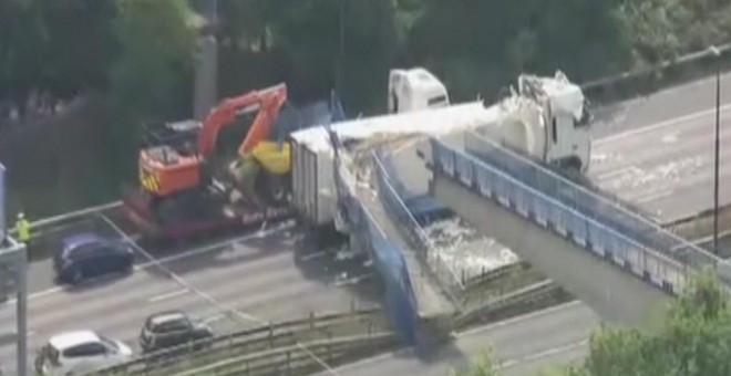 Imagen aérea del puente peatonal desplomado sobre un camión en la carretera que conecta Londres con el canal de la Mancha