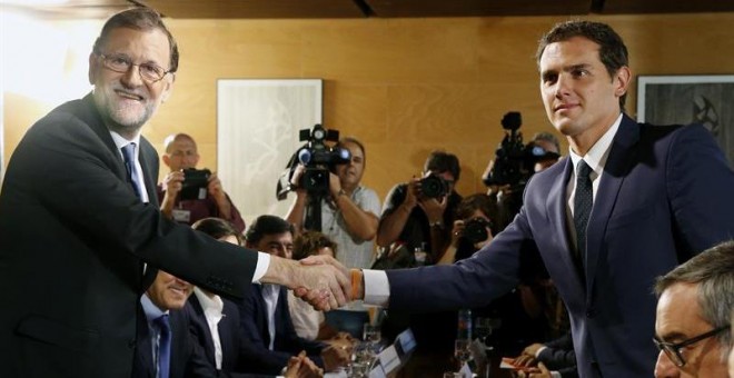 El jefe del Gobierno, Mariano Rajoy,iz., y el líder de Ciudadanos, Albert Rivera, se estrechan la mano durante la reunión de sus respectivas delegaciones en la que van a certificar el acuerdo de investidura-.EFE/Sergio Barrenechea