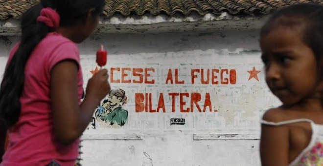 Dos niños en una de las calles de El Paulo, Cauca (Colombia), frente un mural alusivo al cese al fuego definitivo entre las FARC y el Gobierno colombiano.  EFE/Christian Escobar Mora