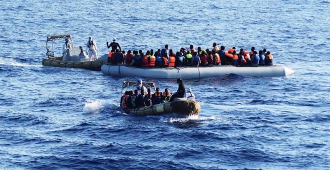 Fotografía facilitada por la Armada italiana que muestra a varios miembros del ejército italiano mientras ayudan a decenas de inmigrantes durante una operación de rescate en el mar Mediterráneo. - EFE