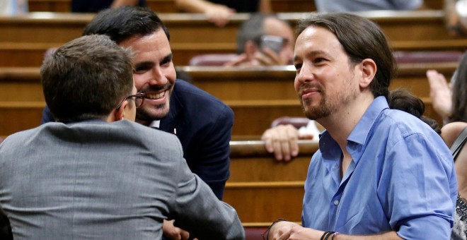 El líder de Podemos, Pablo Iglesias, junto a los miembros de Unidos Podemos, Iñigo Errejón (de espaldas) y Alberto Garzón, instantes previos al debate de investidura de este miércoles en el Congreso de los Diputados.- REUTERS