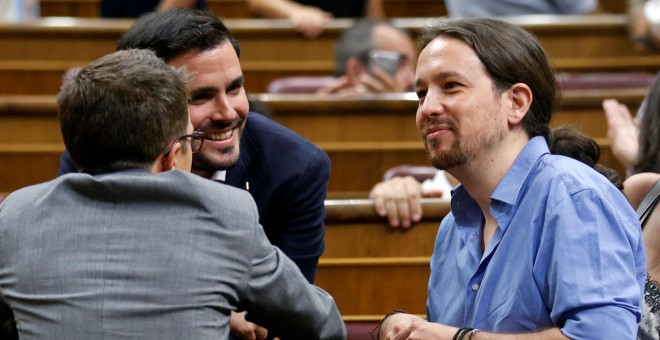 El líder de Podemos, Pablo Iglesias, conversa con su compañero de partido Íñigo Errejón y con el líder de Izquierda Unida, Alberto Garzón antes del debate de investidura que se celebró en el Congreso de los Diputados. REUTERS/Andrea Comas