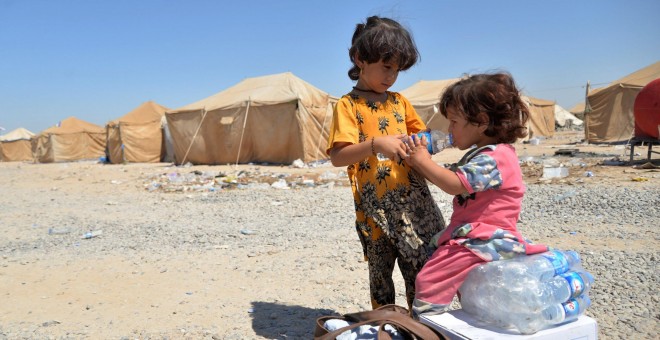 Niños iraquíes migrantes desde Siria reciben suministros de ayuda en un campamento de refugiados en Baiji, al norte de Bagdad. REUTERS/Stringer