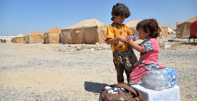 Niños iraquíes migrantes desde Siria reciben suministros de ayuda en un campamento de refugiados en Baiji, al norte de Bagdad. REUTERS/Stringer