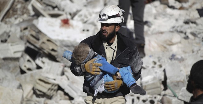 Un hombre coge en brazo el cadáver de un niño muerto en un bombardeo realizado en la provincia de Idlib por aviones rusos, según el testimonio de diversos activistas. - REUTERS