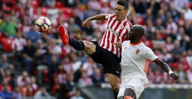 El delantero del Athletic Aritz Aduriz (i) supera al defensa francés del Valencia Eliaquim Mangala para conseguir el segundo gol. /EFE