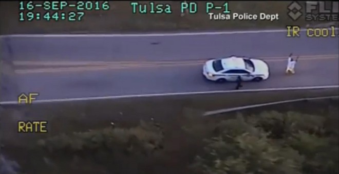 Imagen del video de la Policía de Tlsa (Oklahoma) en la que se ve a  Terence Crutcher de rodillas con las manos en alto, apuntado por varios agentes después de tener una avería en la carretera. REUTERS