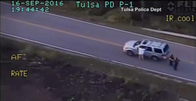 Imagen del video de la Policía de Tlsa (Oklahoma) en la que se ve a  Terence Crutcher junto a su vehículo apuntado por varios agentes después de tener una avería en la carretera. REUTERS