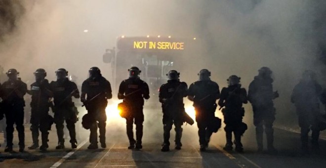 Los agentes de policía con material antidisturbios bloquean una carretera durante las protestas después que la policía disparase fatalmente a un hombre en el estacionamiento de un complejo de apartamentos en Charlotte. REUTERS/Adam Rhew