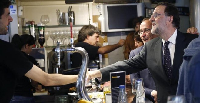 Rajoy saluda a un camarero en un bar de San Sebastián junto a Alonso, hace unos días. EFE/Javier Etxezarreta
