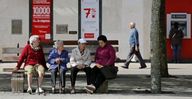 Varios pensionistas sentados en un banco cerca de una oficina bancaria en la localidad burgalesa de Briviesca. AFP / César Manso