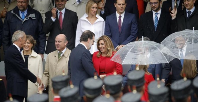 El presidente del Gobierno en funciones, Mariano Rajoy, saluda a la presidenta de Andalucía, Susana Díaz, a su llegada al acto central del Día de la Fiesta Nacional, en el que se rinde homenaje a la Bandera y a los que dieron su vida por España, y que cue