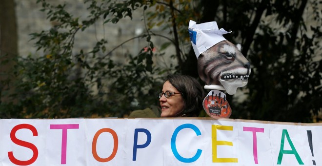 Una manifestante contra la firma del CETA frente al parlamento regional valón en Namur, Bélgica. / REUTERS