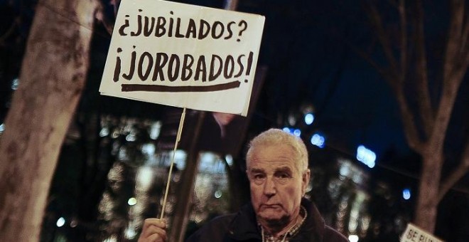 Manifestante con un pancarta en una protesta contra los recortes. AFP