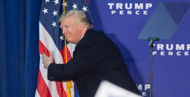 Donald Trump abraza una bandera de EEUU durante un acto de campaña en  Leesburg, Virginia. - EFE